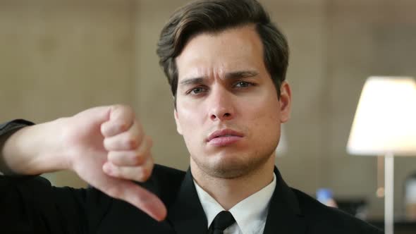 Thumbs Down by Frustrated, Angry Businessman in Office