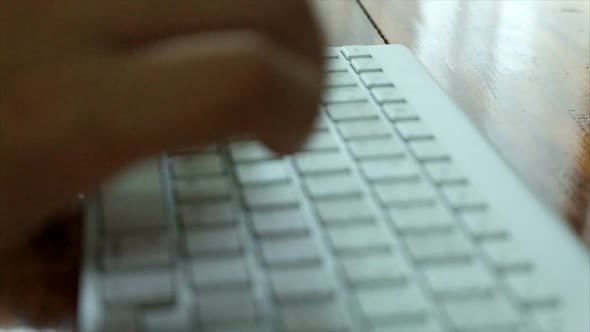 Close up of business man hands typing on a  computer keyboard, white keyboard