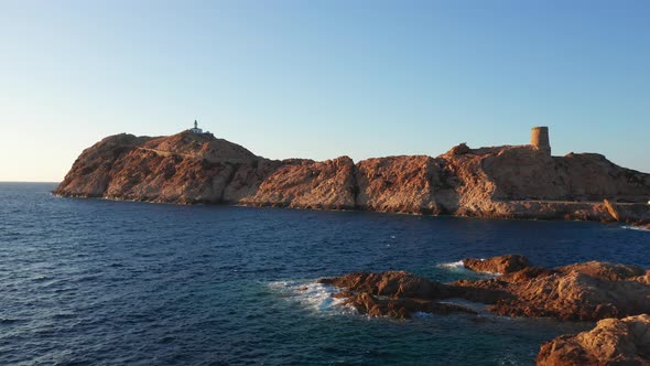 Aerial View of a Desolated Lighthouse in the Middle of a Desert Island in the Ocean Sea with Curved