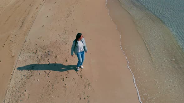 Happy Brunette Woman Walks Along Beach Near Ocean