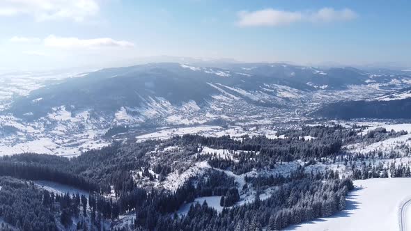 Aerial View Over a City Between Mountains In Winter