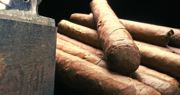 Cigars in humidor with lighter. View through a cigar cutter.