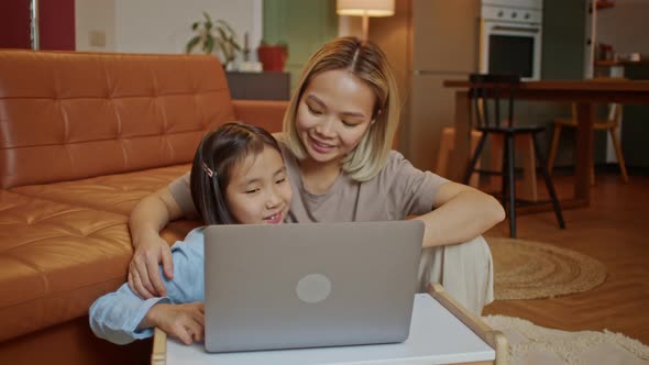 Young Mother with Child Working on the Computer