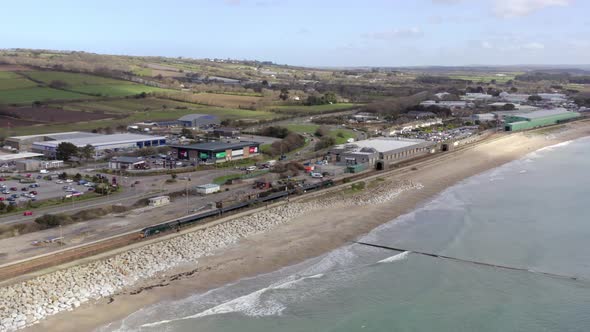 Commuter Train Accelerating Alongside the Sea