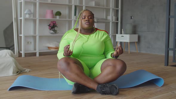 Yogi Plump African Woman Meditating in Lotus Pose