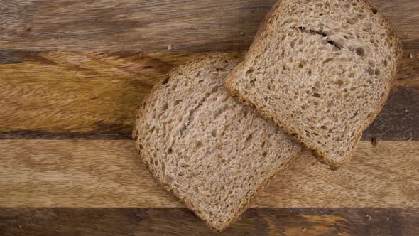 Sliced rye dark bread with crumbs falling on the board close-up