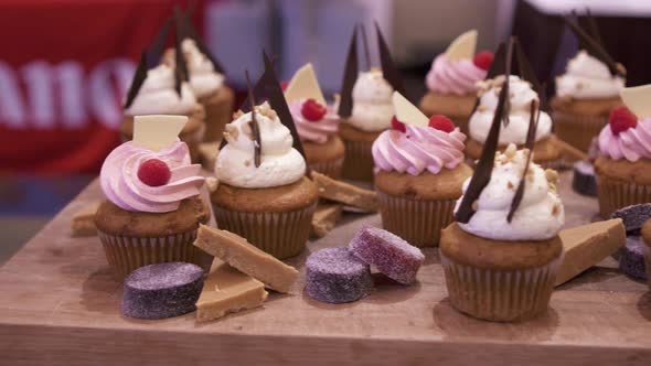 A panning shot across many cupcakes and other desserts.