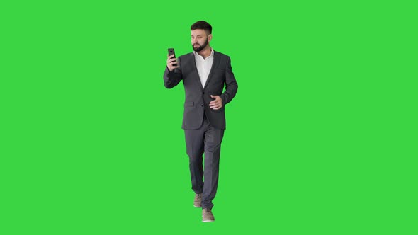 Businessman Walking and Making a Video Call on a Green Screen, Chroma Key.