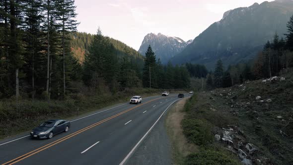 Mountain Highway Aerial With Cars Traveling By High Peak alt