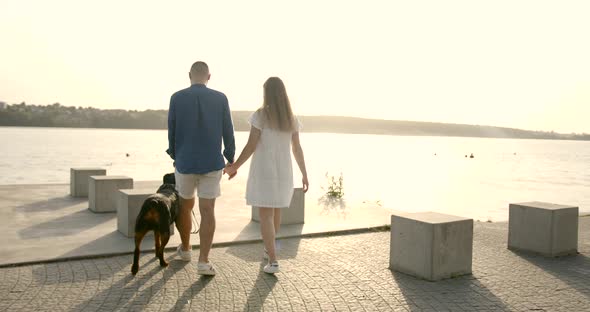 Young European Couple Going Near Lake with Dog