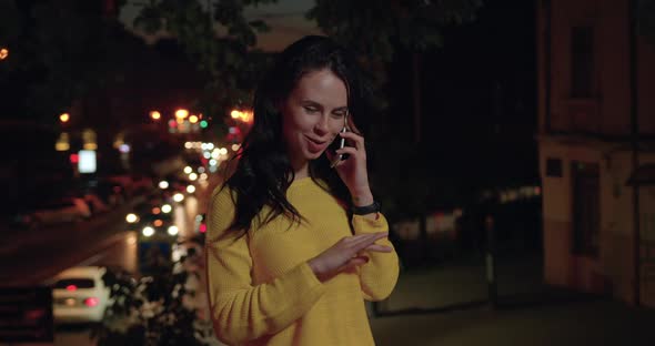 Girl in Casual Clothes which Standing on the Background of Lights Night City