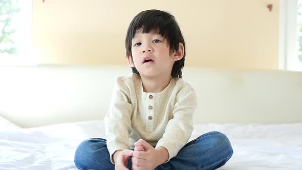 Asian Child Sitting And Looking At Camera