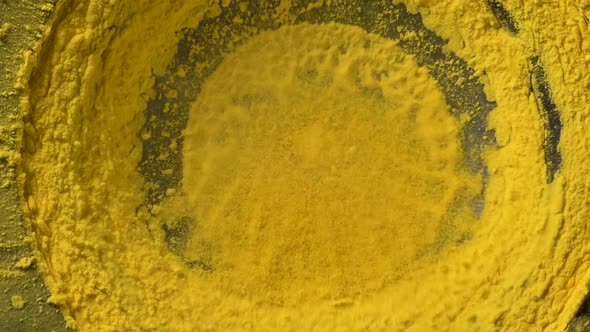 Yellow Holi Paint Powder Jumps and Pours on Large Subwoofer