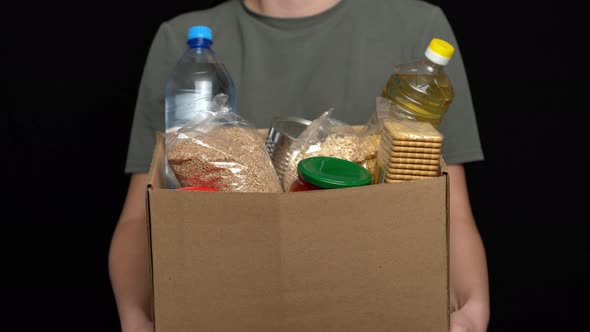 Volunteer Putting Food in a Donation Box. Charity Concept