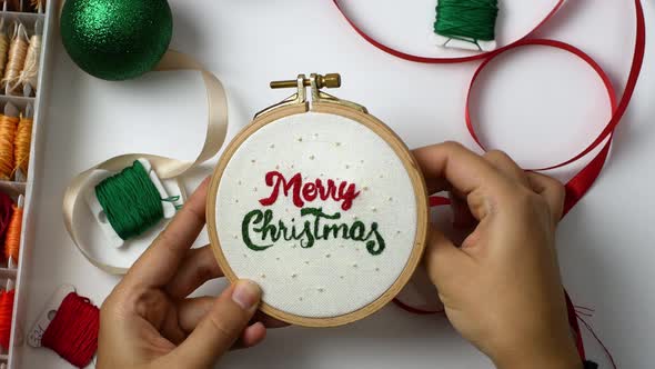 Woman-making handmade Christmas embroidery. Crafts, Holidays.