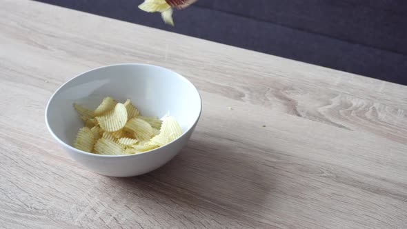 the shot of potato chips pouring in the bowl