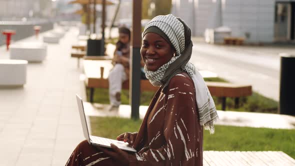 Woman with Computer Posing on Bench