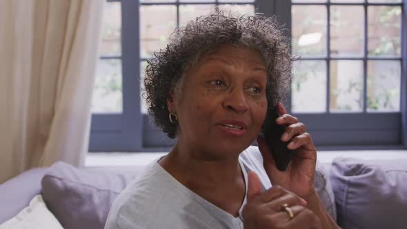 Senior mixed race woman using a smartphone. Social distancing and self isolation in quarantine