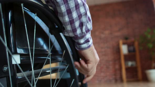 Closeup Male Hand Turning Wheels of Wheelchair