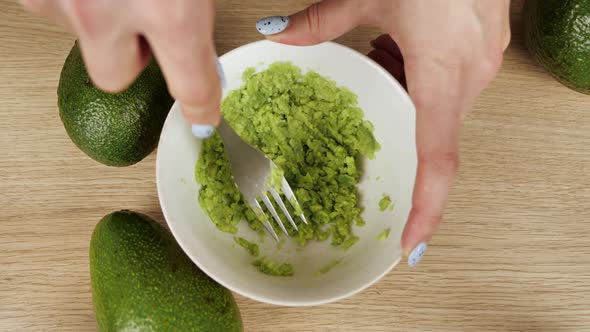 Mashing Avocado in Bowl with a Fork