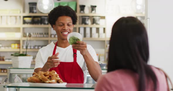Animation of happy biracial waiter selling food to female customer