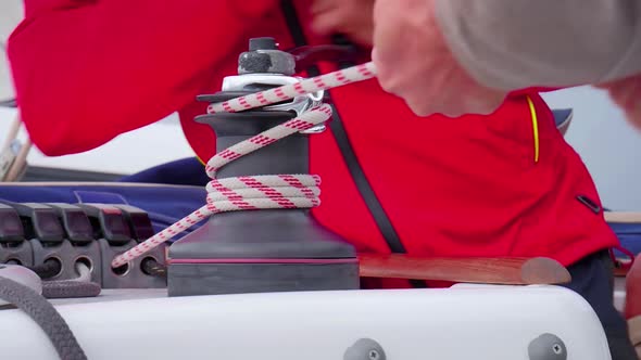 Sailors Turning The Hand Crank Of A Self-tailing Winch To Adjust The Tension Of The Rope - close up