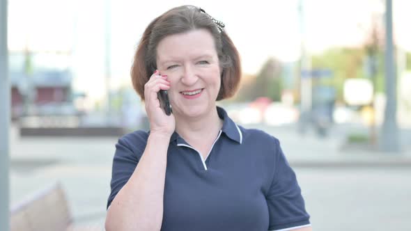 Old Woman Talking on Phone While Standing Outdoor