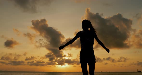 Silhouette of woman with seascape in the sunset time 