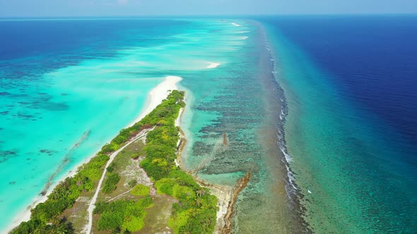 Natural flying tourism shot of a white sand paradise beach and turquoise sea background in 4K