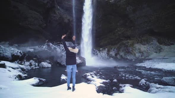 Woman Traveler Under Famous Waterfall Seljalandsfoss in Iceland