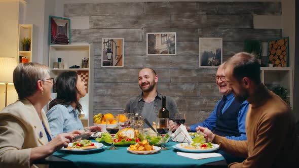 Young Man Telling a Joke at Sunday Night Family Dinner