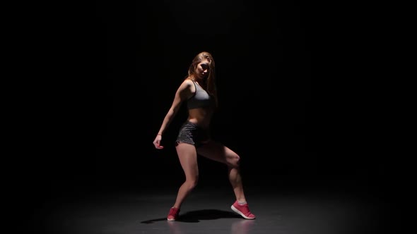 Woman Dancing Hip-hop in Dark Studio Face To the Viewer