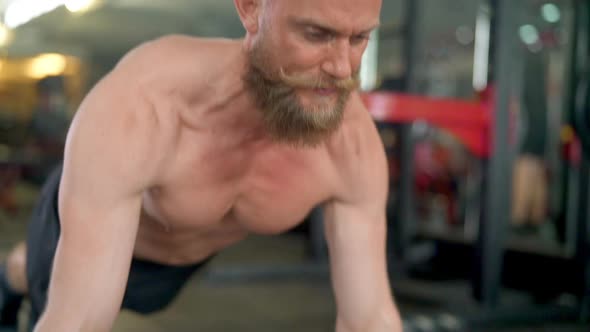 Fit Guy in an Indoor Gym Doing Push Ups with Veins Showing