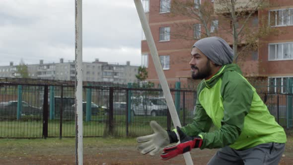 Goalkeeper Catching Soccer Ball and Returning It while Training Outdoors