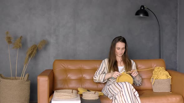 Young Woman Crocheting with Knit Needles Home Decor from Eco Materials at Home, Copy Space