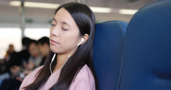 Woman sleeping on ferry and listen to music