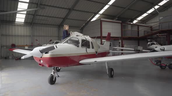 Pilot discovering light aircraft with protective cover in hangar