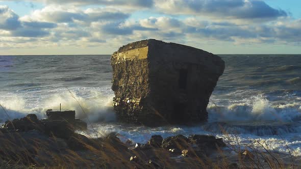 Big stormy waves breaking against abandoned seaside fortification building at Karosta Northern Forts