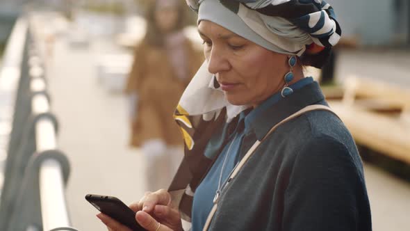 Mature Woman Using Smartphone Outdoors