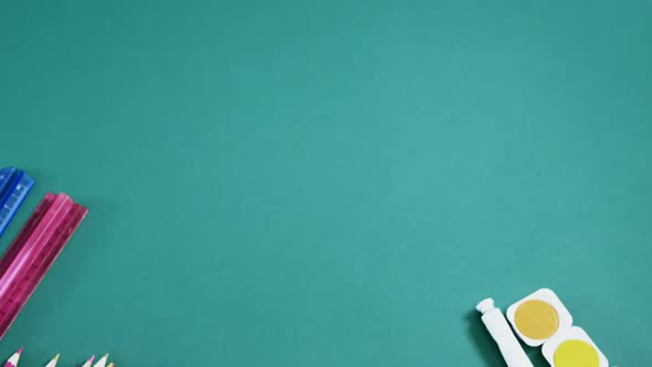 School supplies arranged on green background