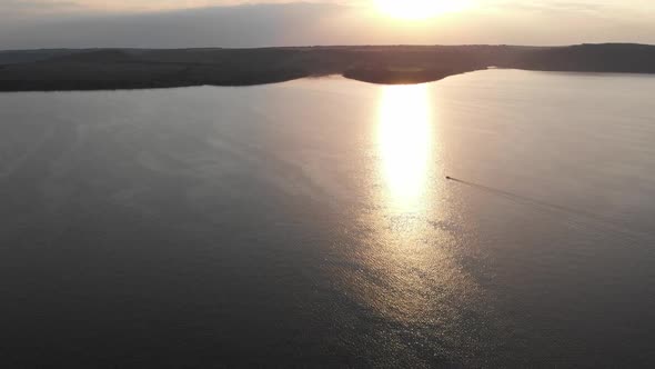 Aerial drone shot: motorboat floating the huge river.