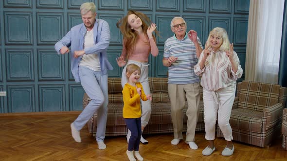 Family Members of Different Generations Having Fun Listening Music Dancing Crazy in Room at Home