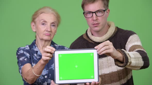 Happy Grandmother and Grandson Showing Digital Tablet Together