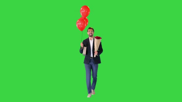 Elegant Man in a Suit with a Bouquet of Flowers a Gift and Balloons Walking on a Green Screen Chroma