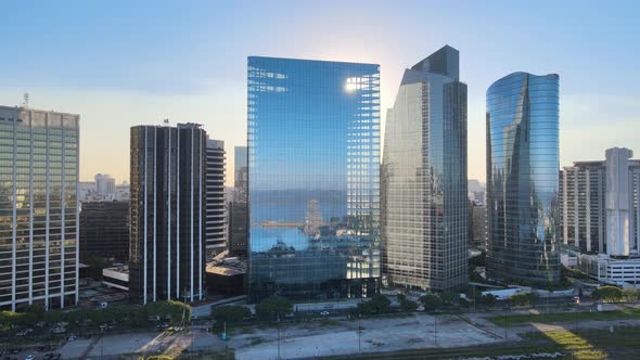 Aerial pan left of high-rise window glass Puerto Madero buildings near Paseo del Bajo highway at sun