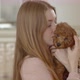 Young beautiful girl holding a poodle puppy in her arms. presses to itself. The puppy yawns. - VideoHive Item for Sale