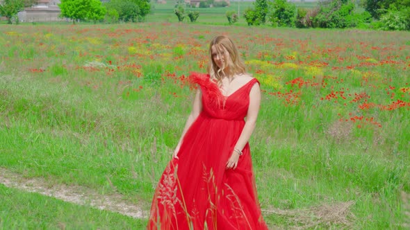 Woman with Red Dress Moves Among the Green Nature