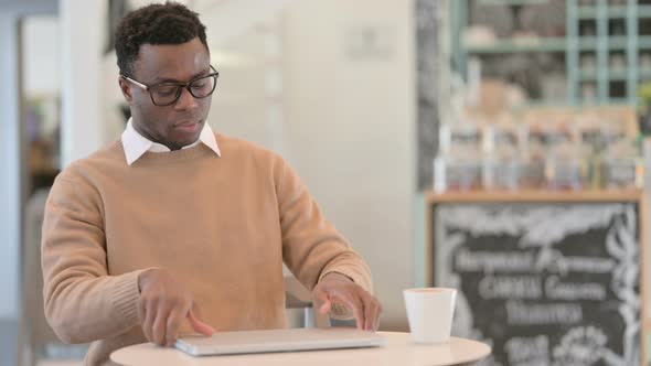 Creative African Man Coming Back Opening Laptop in Cafe
