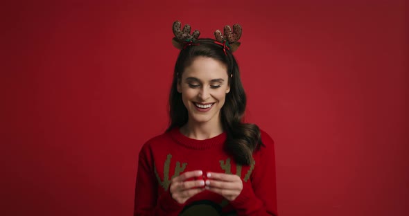 Woman in Christmas costume on red background