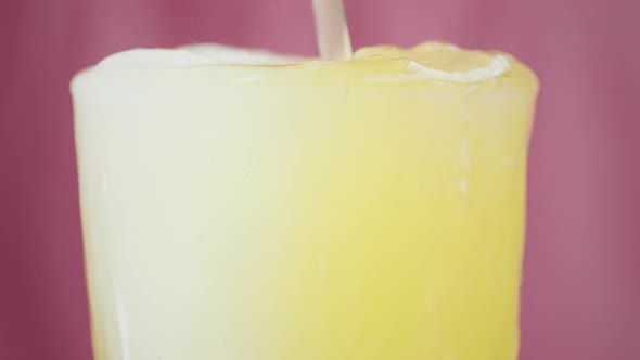 Lemonade spills over a glass